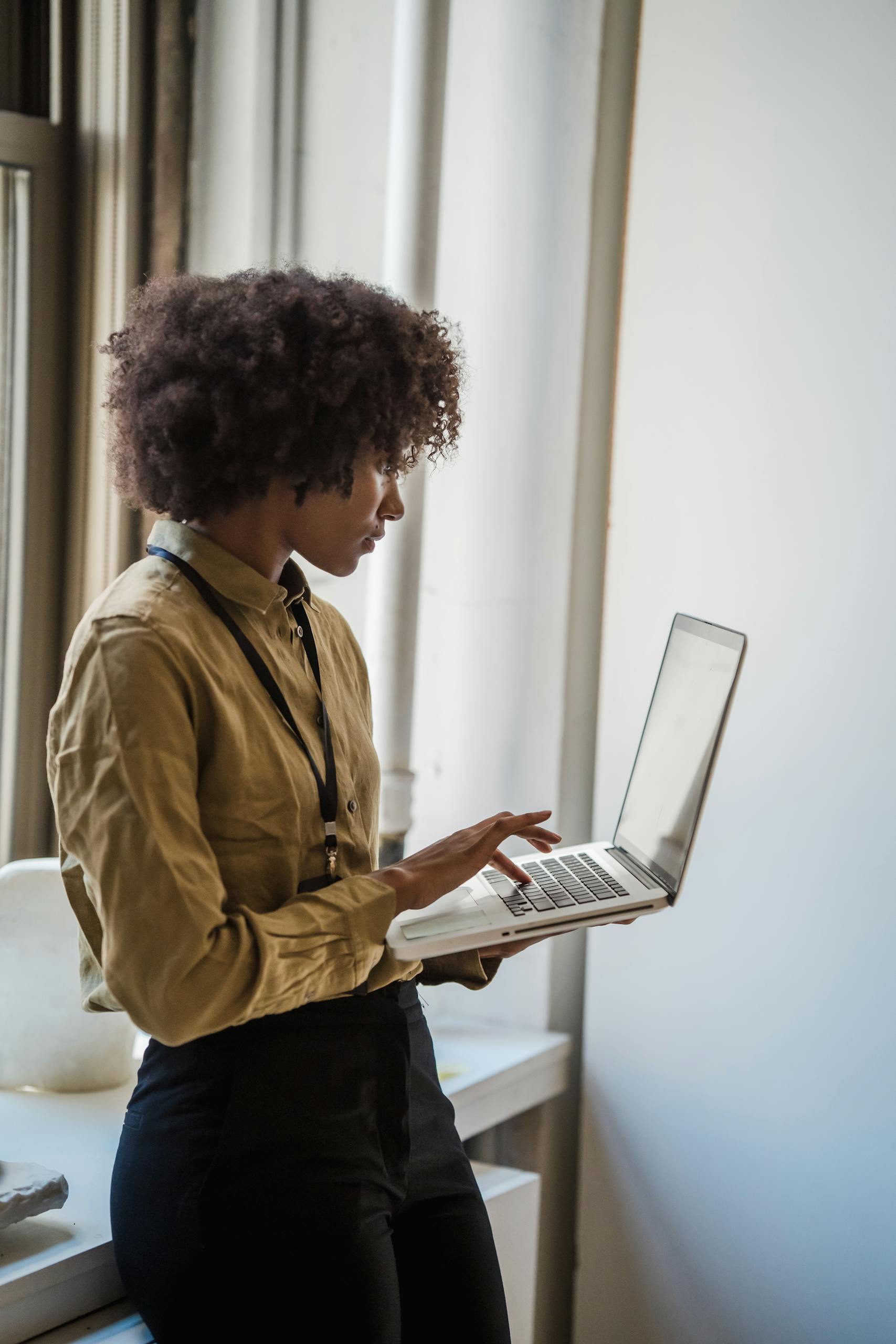 Woman Standing and Typing on Laptop Keyboard